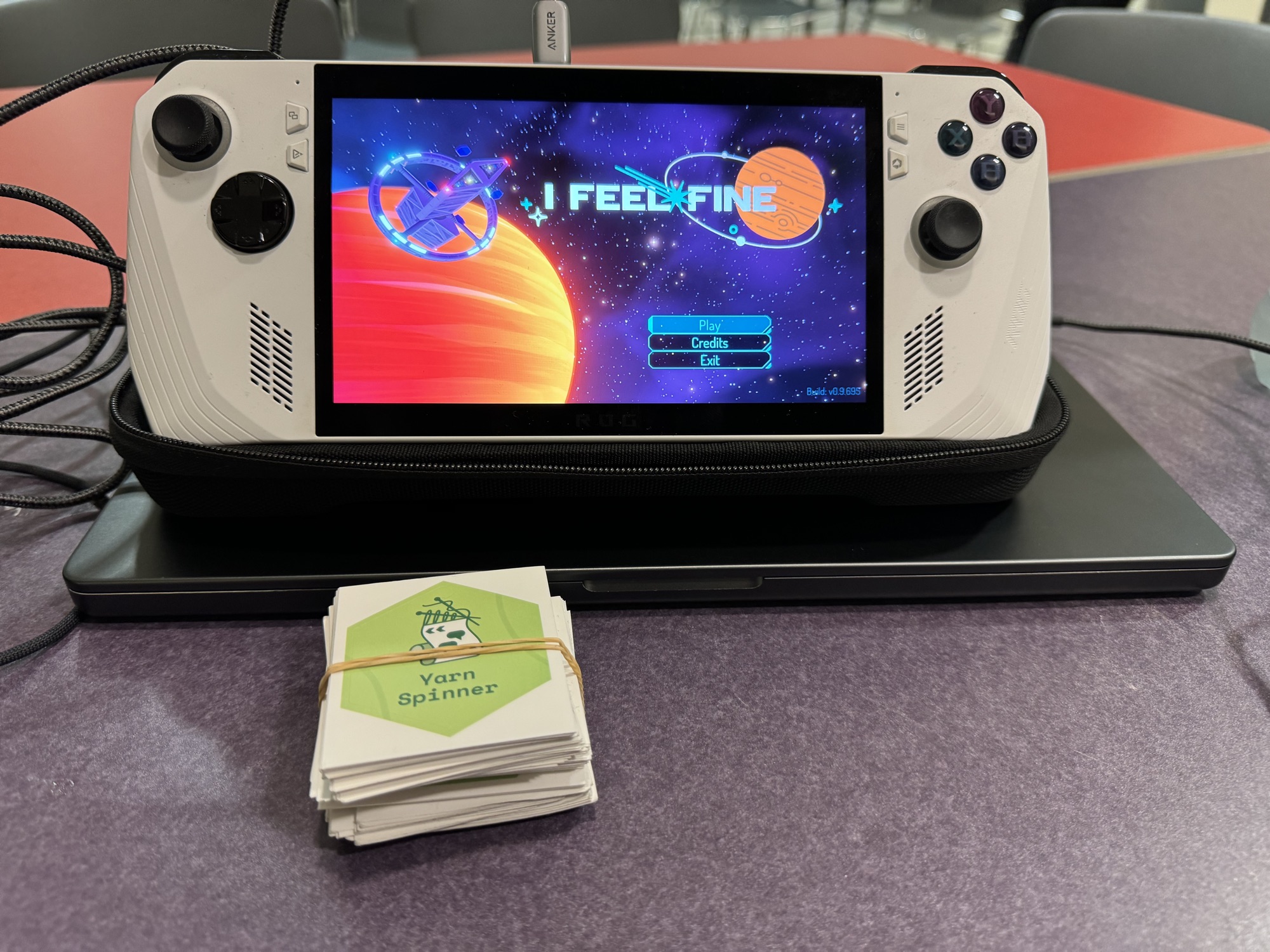I Feel Fine running on a handheld gaming PC, with a rubber-banded stack of Yarn Spinner stickers in front